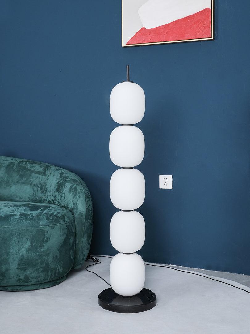 Unlit lamp against a navy wall, its five white globes reading as plain matt glass.
