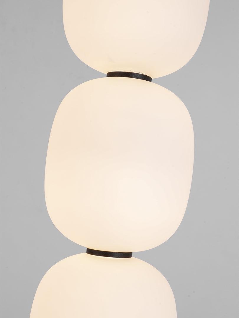 Close view of two globes meeting at the slim black collar that joins them.