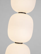 Close view of two globes meeting at the slim black collar that joins them.