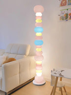 Beside a white sofa and a small stool shaped like a dog, this Clérachic floor lamp's globes glow in a bright room.