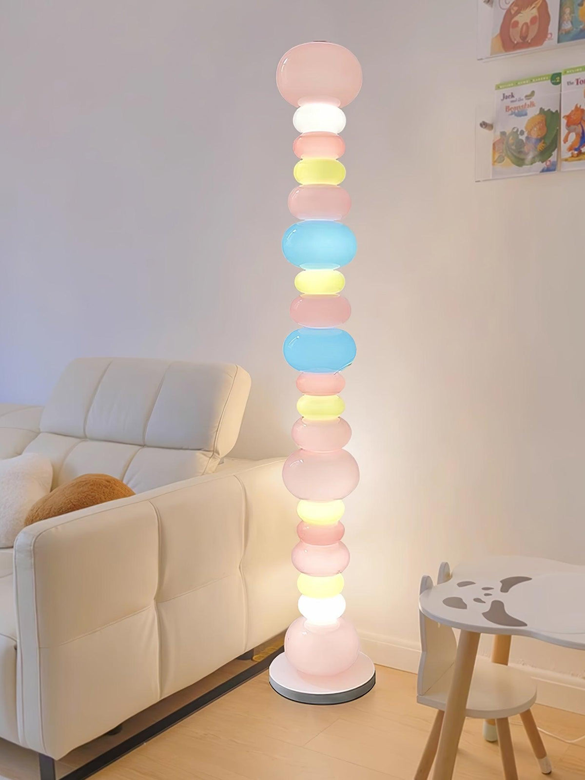 Beside a white sofa and a small stool shaped like a dog, this Clérachic floor lamp's globes glow in a bright room.