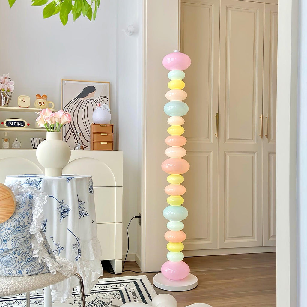 Clérachic multicolour floor lamp glowing in a bright dining corner, near a blue-and-white tablecloth and potted plants.