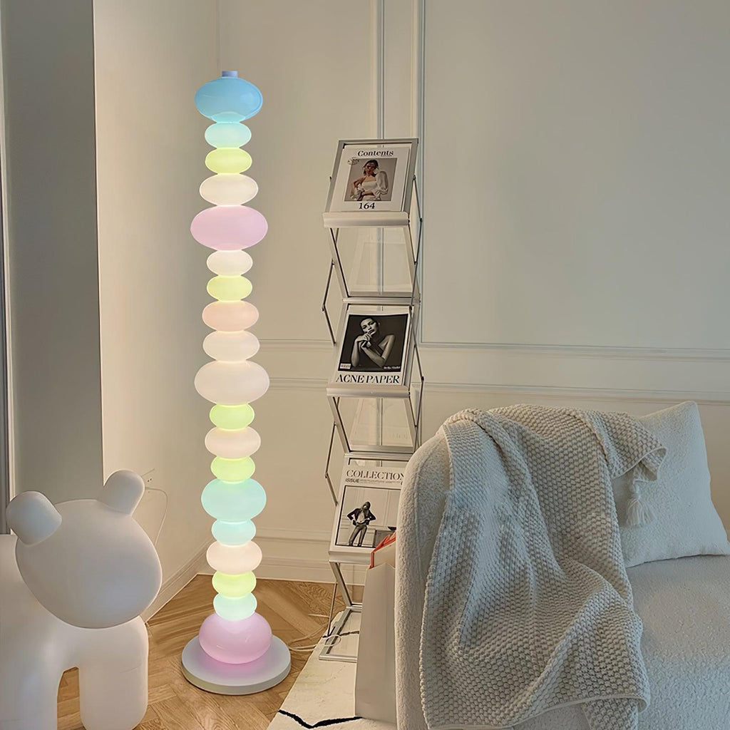 Near a ladder shelf of framed photographs and a bear figure, this Clérachic floor lamp's globes glow beside a cream throw.