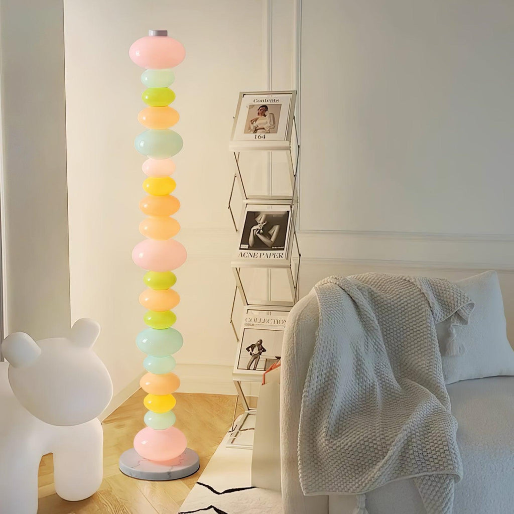 Near a ladder shelf of photographs and a bear figure, this Clérachic floor lamp's globes glow beside a soft cream throw.