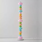 Standing alone on a pale studio backdrop, this Clérachic floor lamp shows its full column of glowing pastel glass globes.