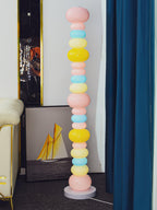 Beside a cream armchair and a blue curtain, this Clérachic floor lamp's globe column glows near framed sailboat art.
