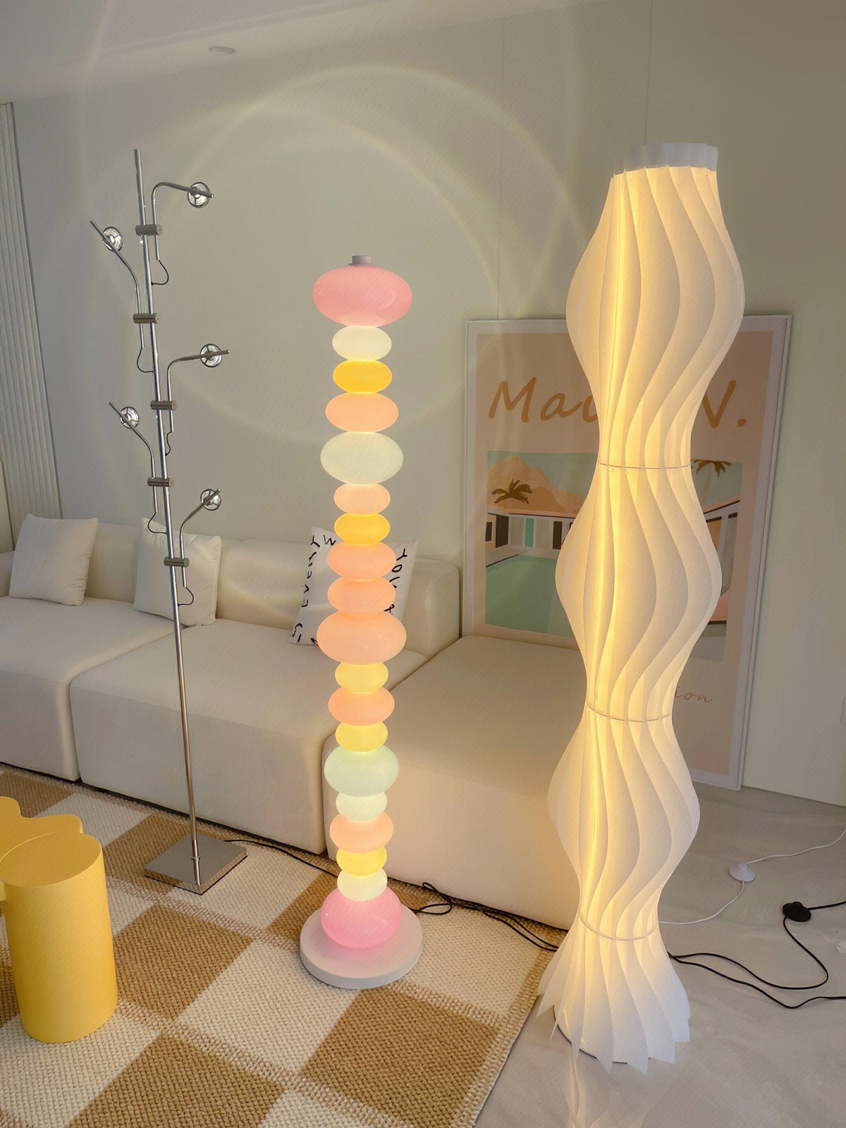 Next to a woven wavy floor lamp and a coat rack, this Clérachic floor lamp's stacked globes glow in a bright room.