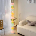 Beside a striped chair and sheer curtains, this Clérachic floor lamp's stacked globes glow near a small side table.