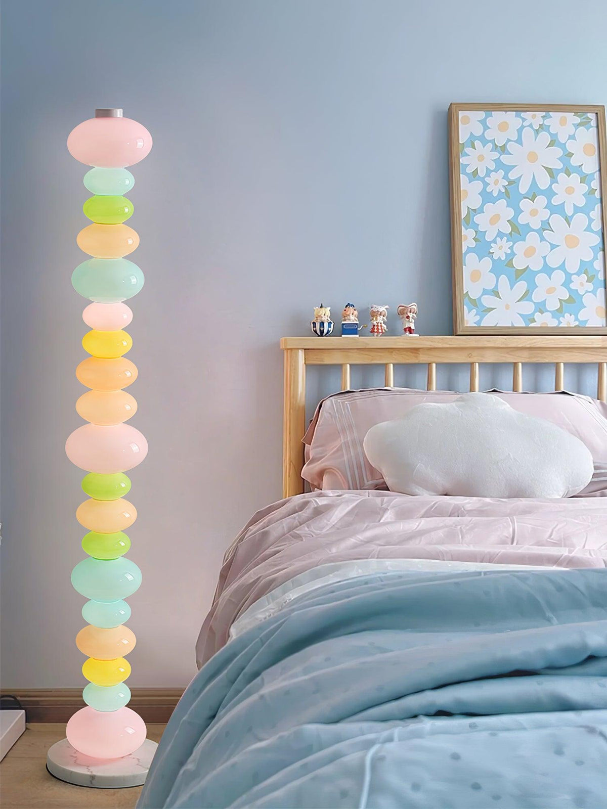 Beside a wooden bed frame and floral wall art, this Clérachic floor lamp's globe column glows in a pale bedroom corner.