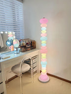 Beside a lit vanity mirror and dressing table, this Clérachic floor lamp's globe column glows on a tan carpet.