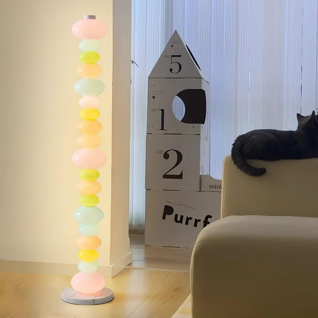 Clérachic glass globe floor lamp lit near a tall cardboard cat shelf, with a black cat perched on a cushion below.