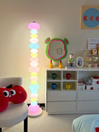Clérachic glass globe floor lamp glowing beside a white dresser with mug cubbies and a plush toy armchair.