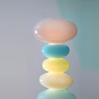 Extreme close-up of a Clérachic glass globe lamp's glossy top orbs against a plain grey background, showing the glass finish.
