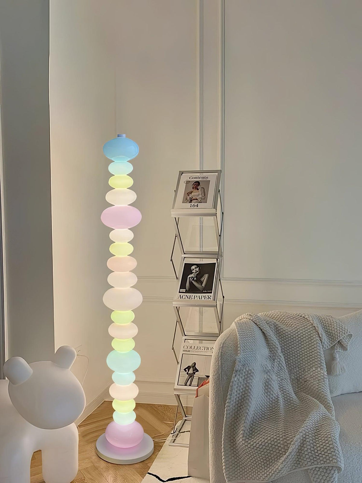 Near a bear-shaped figure and a shelf of framed photographs, this Clérachic floor lamp's stacked globes glow softly.