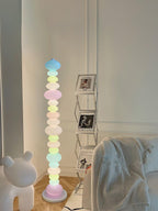Beside the same bear figure and photo shelf, this Clérachic floor lamp shows a blue globe glowing at its crown.
