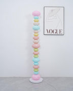 Clérachic multicolour floor lamp shown unlit in a plain room, its pastel glass globes lit only by daylight.
