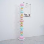 Clérachic glass globe floor lamp shown unlit in daylight beside a 'VOGUE' wall print, its pastel colours flat and matte.