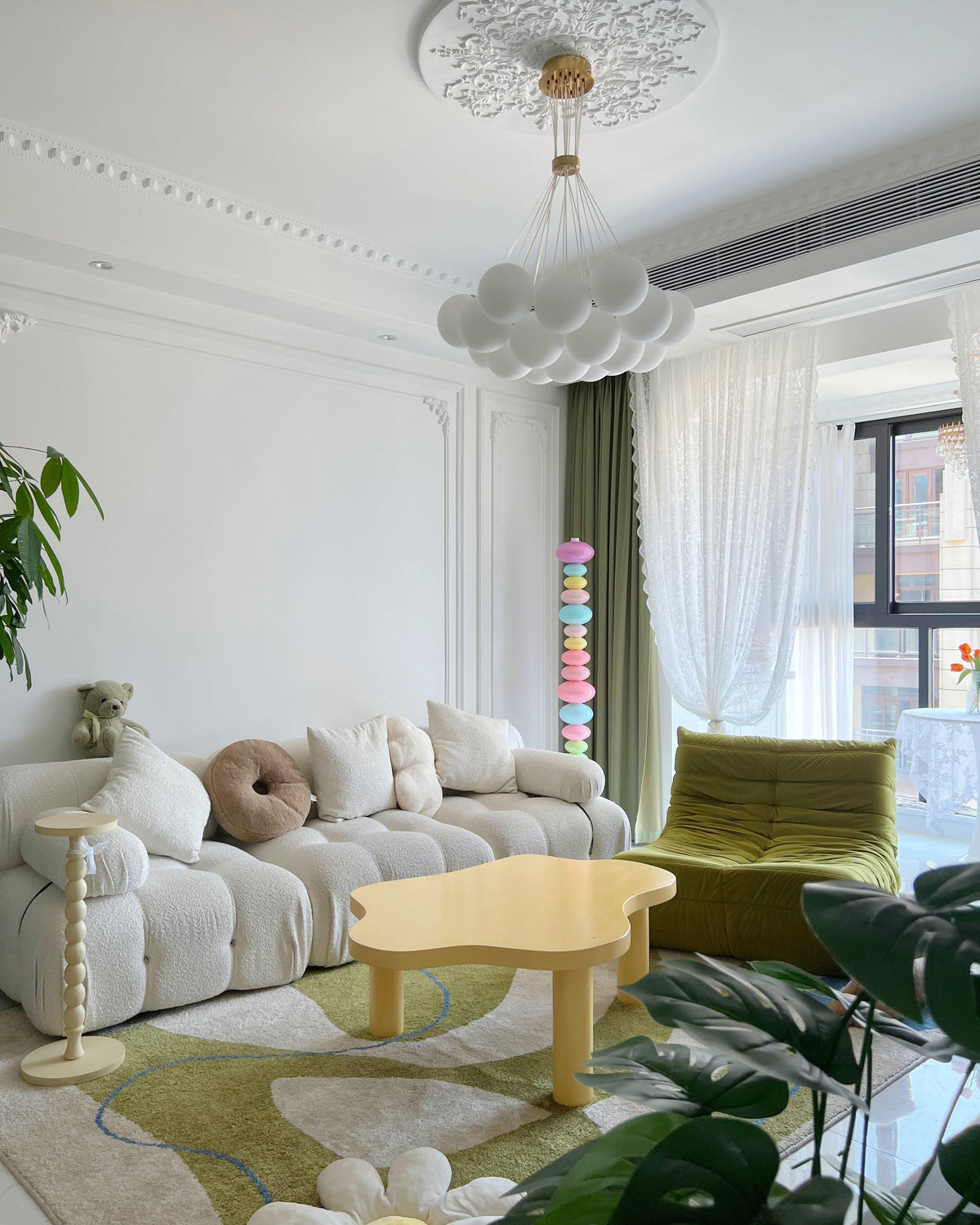 Wide living room view with a Clérachic glass globe floor lamp glowing faintly near the window, beyond a boucle sofa.