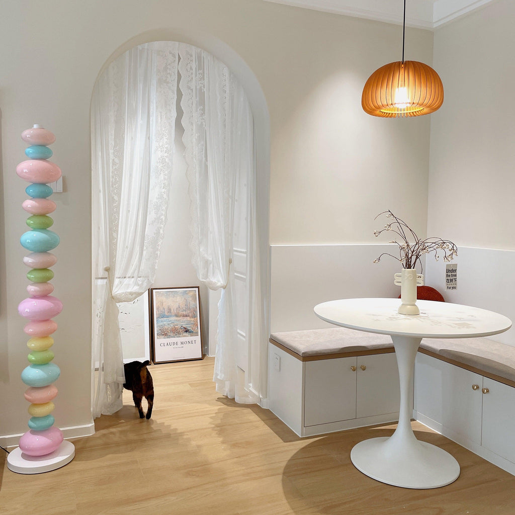 Clérachic glass globe floor lamp lit in a hallway as a black cat walks past a round dining table nearby.