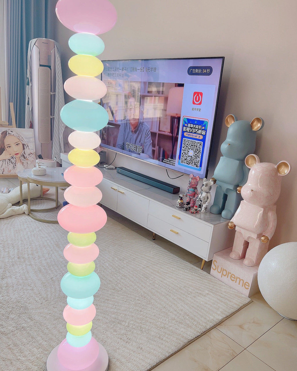 Clérachic stacked glass globe lamp lit beside a TV stand and oversized collectible bear figures on tiled floor.