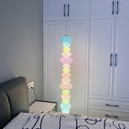 Close crop of a Clérachic glass globe lamp glowing against white wardrobe doors and dark bedside furniture.