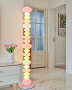 Clérachic multicolour floor lamp lit beside a white dresser with a tulip vase, near a glazed panelled door.