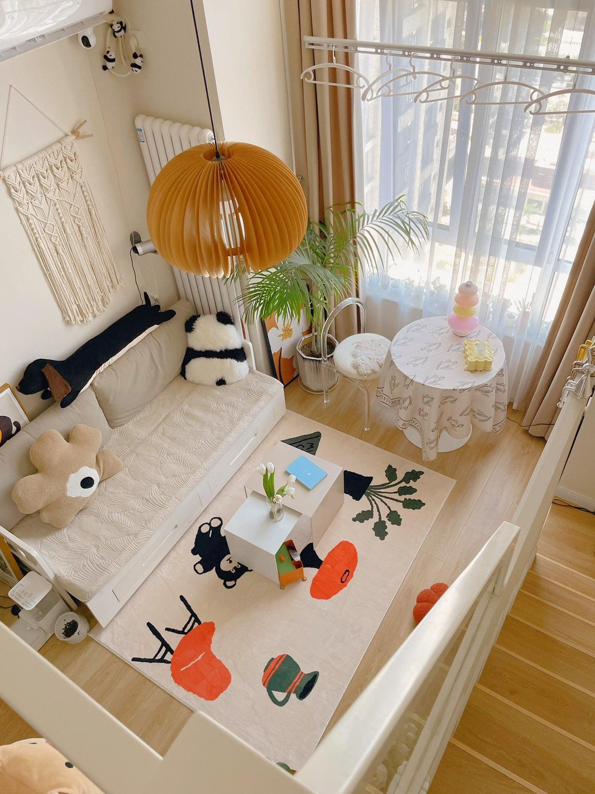 Clérachic multicolour floor lamp lit in a nursery corner with a colourful play rug and a macrame wall hanging.