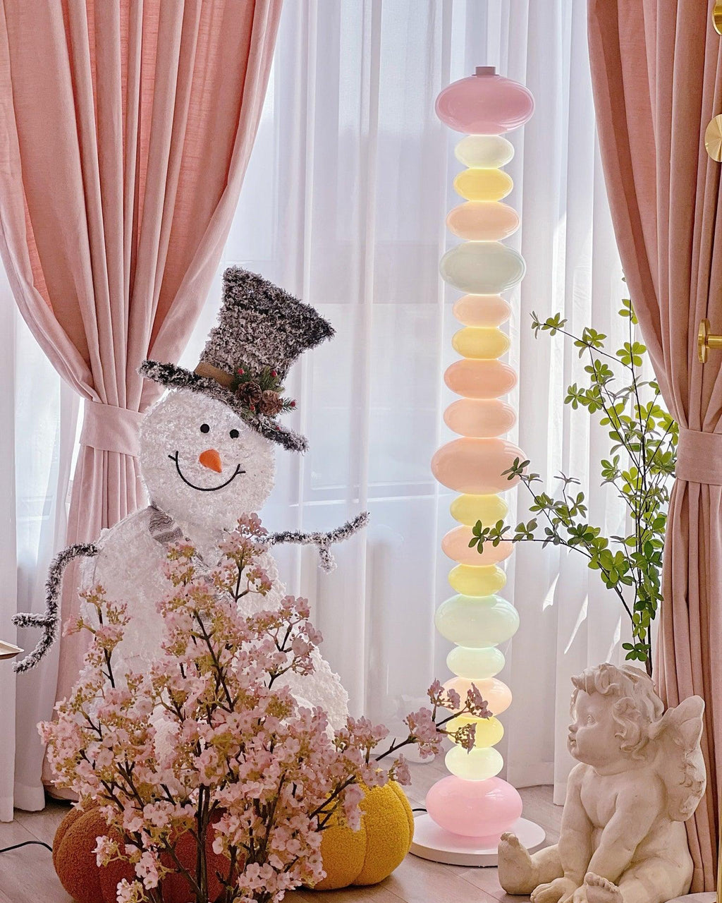 Styled among sheer curtains and a small figurine display, this Clérachic floor lamp's globes glow in soft pastel tones.