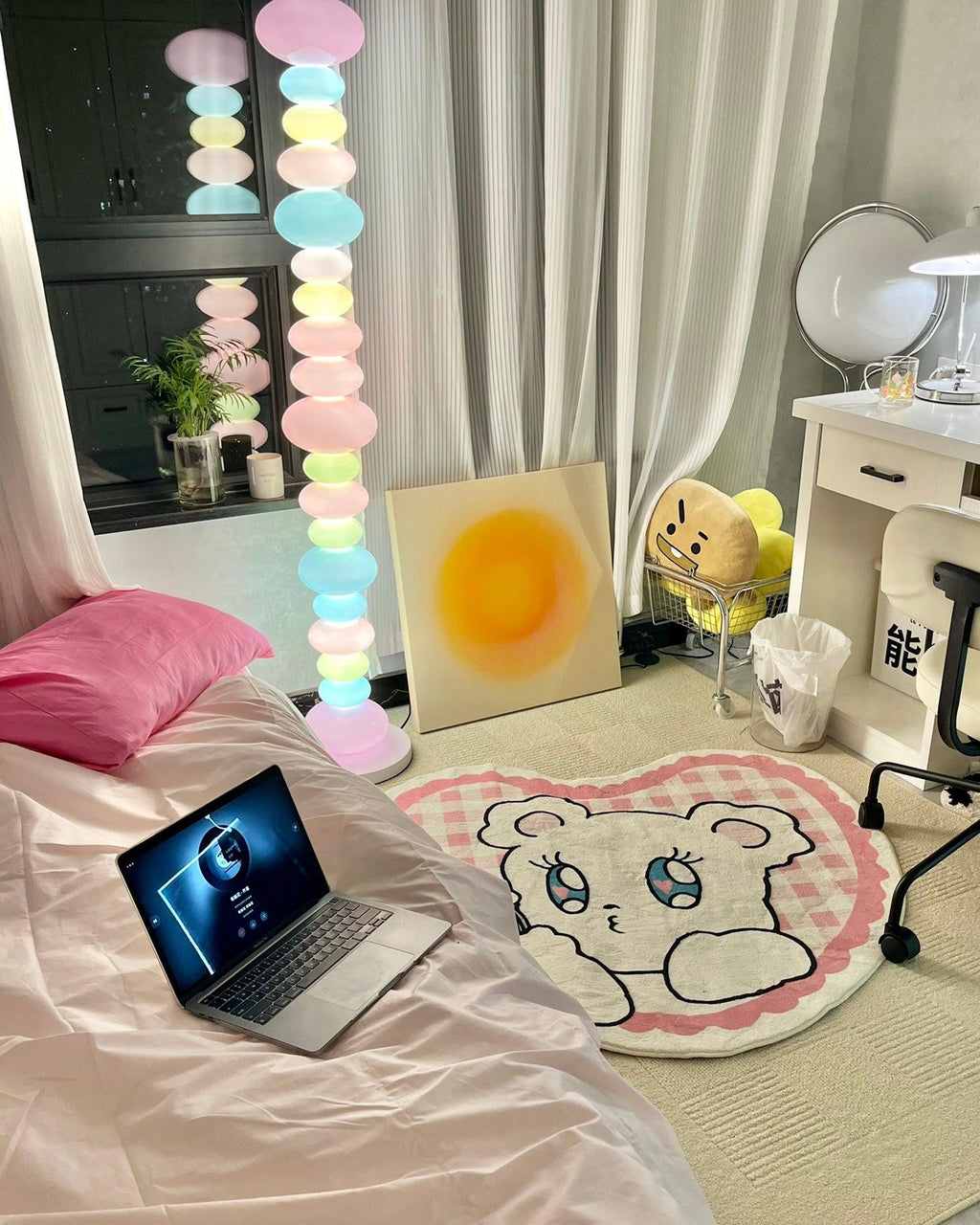 Beside a pink-pillowed bed with a laptop and a bear-shaped rug, this Clérachic floor lamp lights a corner of the bedroom.