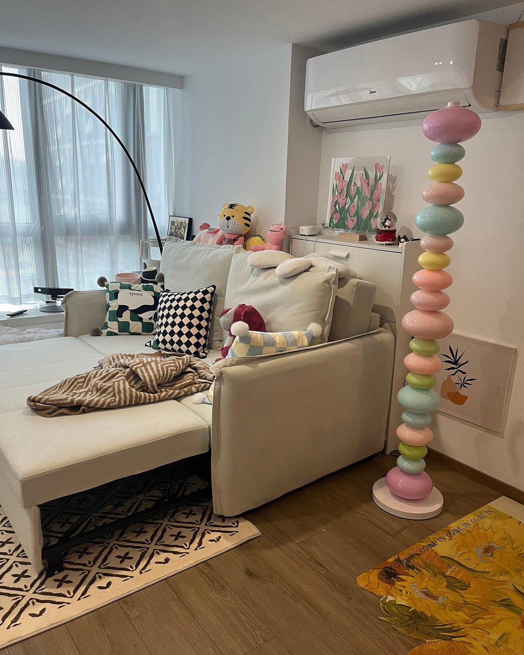 Positioned near a beige sofa and patterned rug, this Clérachic floor lamp's globe column glows in a softly lit living room.