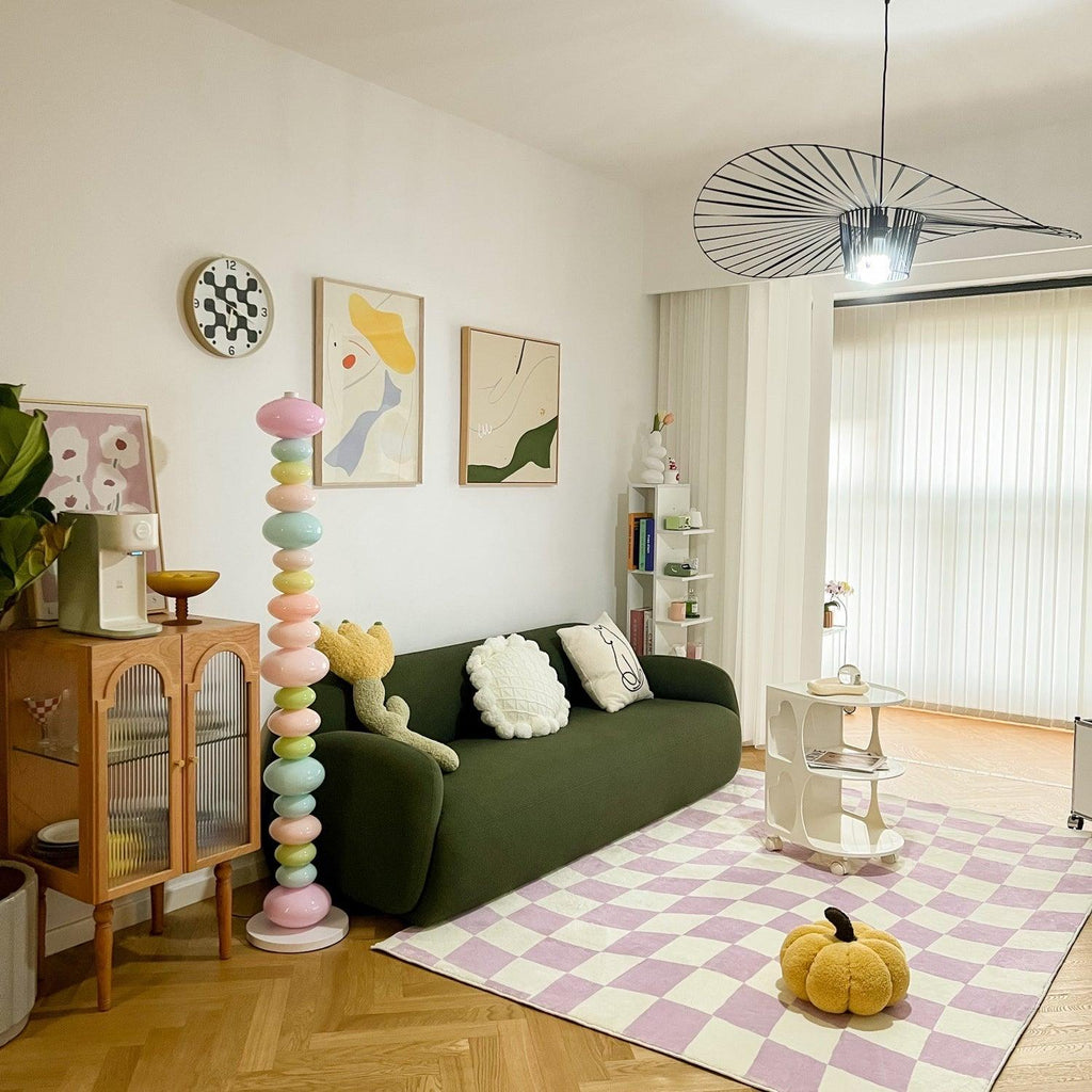 Beside a green sofa and checked pink rug, this Clérachic floor lamp's stacked globes stand tall against a gallery wall.