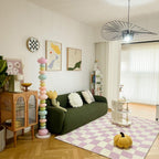 Beside a green sofa and checked pink rug, this Clérachic floor lamp's stacked globes stand tall against a gallery wall.
