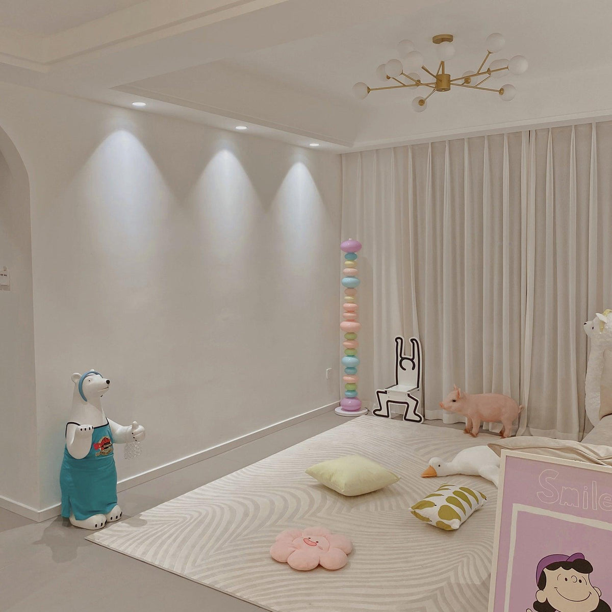 Near a polar bear figure and a floor cushion under recessed lighting, this Clérachic floor lamp's globes glow softly.