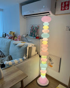 In a bedroom with a plush toy on the bed and wall art nearby, this Clérachic floor lamp's globe column glows warmly.