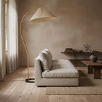 Beech wood floor lamp with soft linen shade against a plain wall