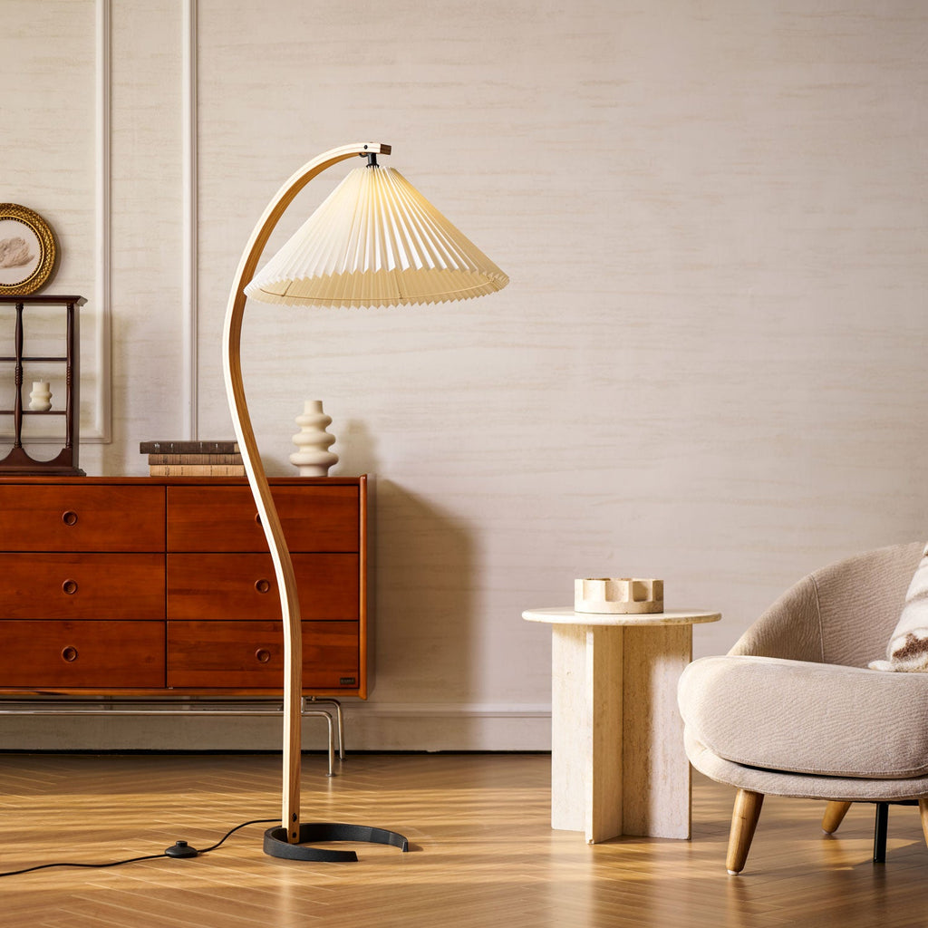 Caprani floor lamp casting soft glow beside a styled armchair