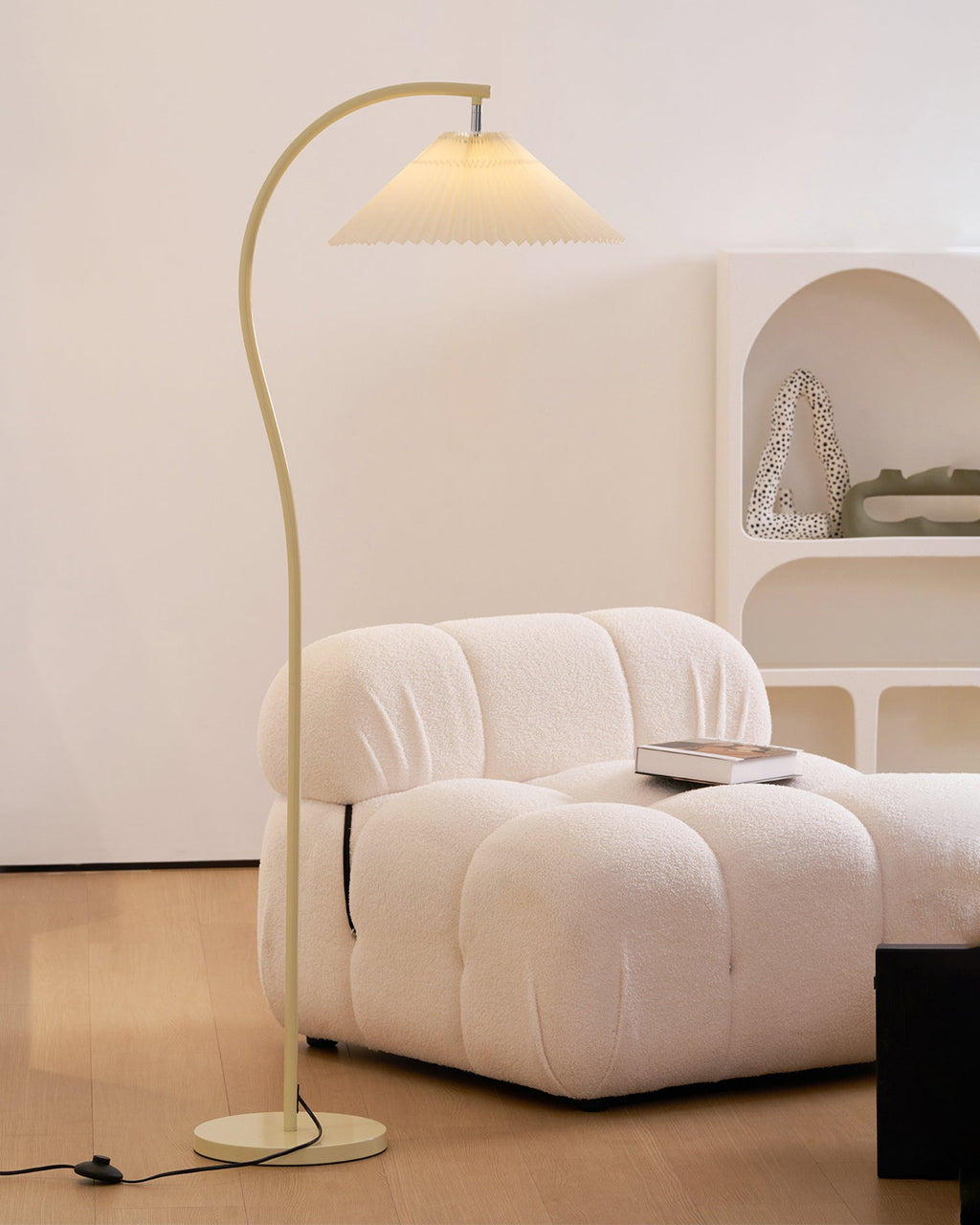 Pleated floor lamp with beech wood frame glowing softly