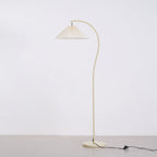 Pleated linen floor lamp lit in a softly furnished room