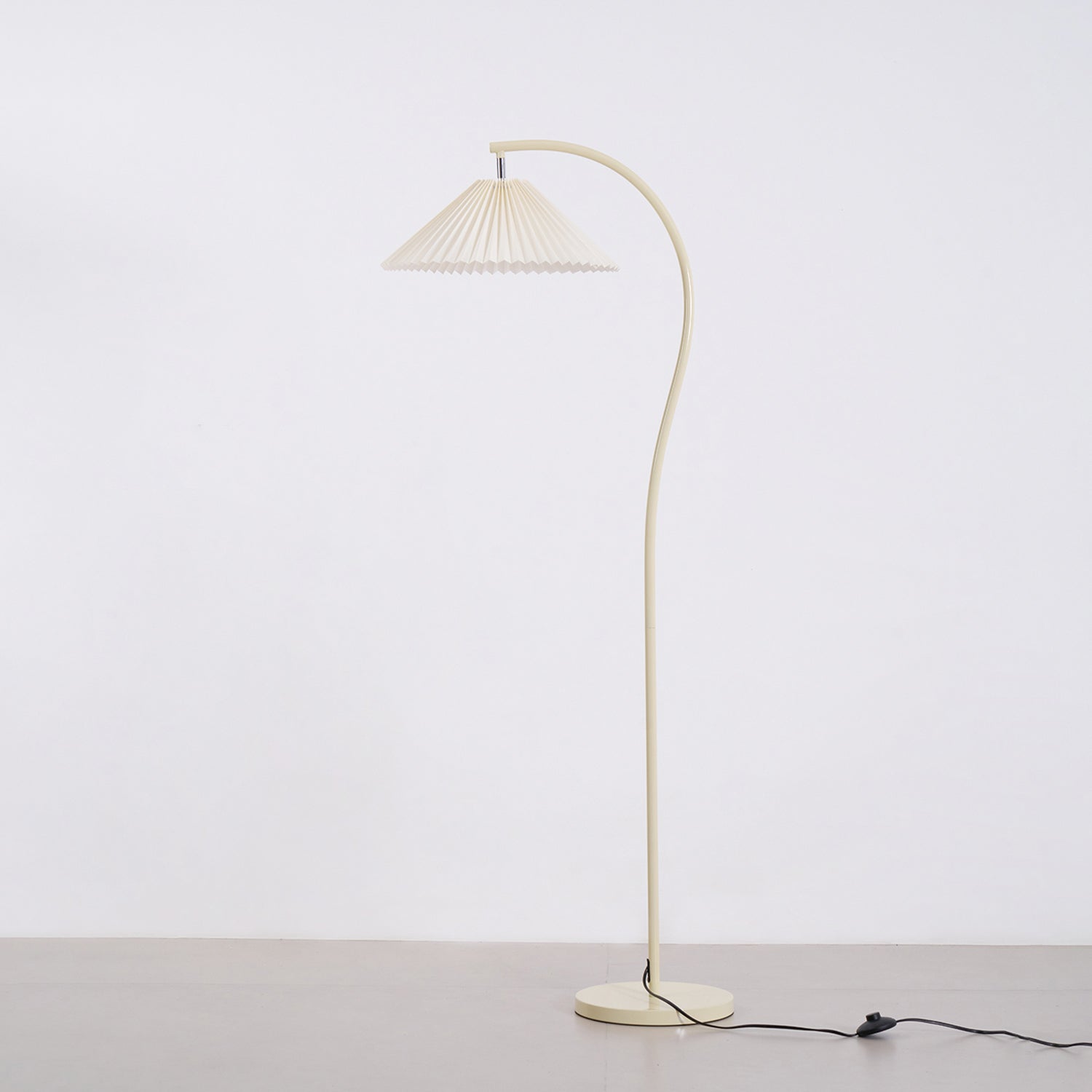 Pleated linen floor lamp lit in a softly furnished room