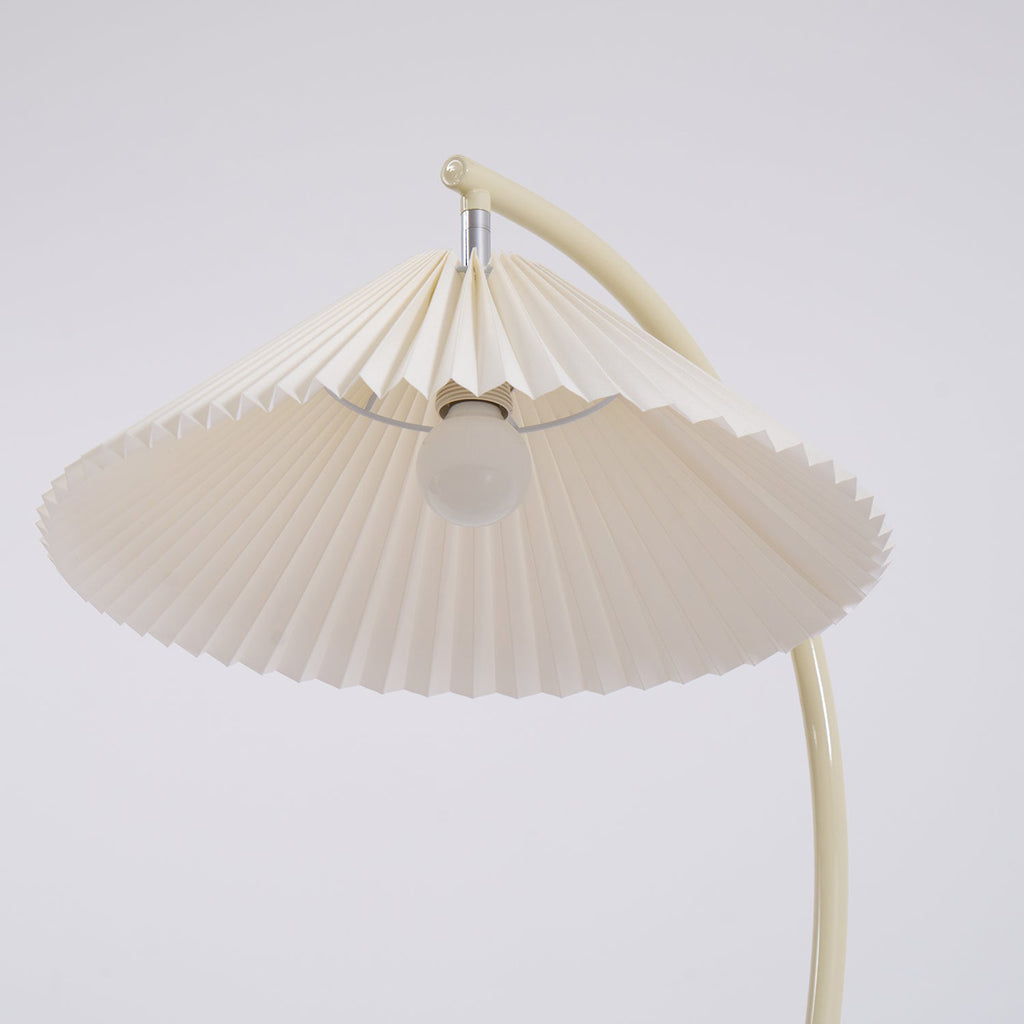 Pleated floor lamp standing in a calm neutral space