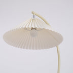 Pleated floor lamp standing in a calm neutral space