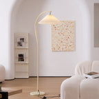 Floor lamp with pleated beige shade standing in a cosy reading corner