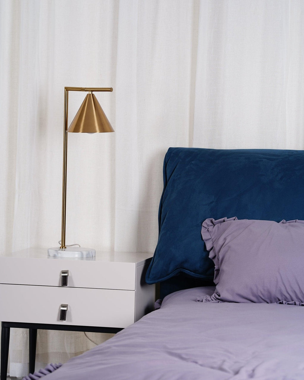 Another angle of the same bedside scene shows the Clérachic lamp against sheer curtains, with the headboard just in frame.