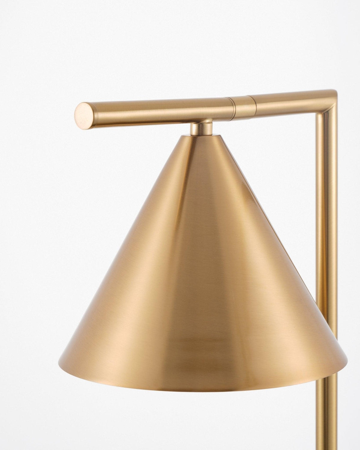 Photographed low and close, this shot shows the exterior of the Clérachic lamp's brass cone shade against a plain background.