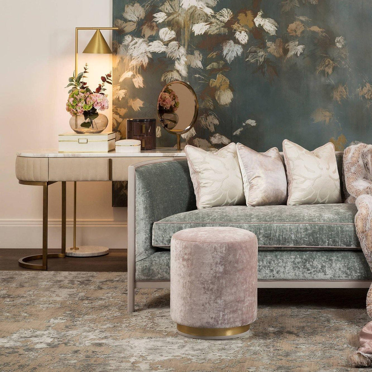 Styled on a mirrored dresser with fresh flowers, the Clérachic lamp sits beside a pink velvet armchair and floral wallpaper.