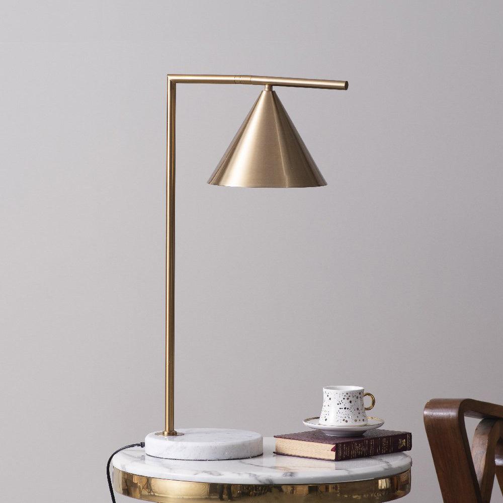 The Clérachic lamp lights a round brass-edged side table set with a teacup, saucer and stacked books in warm daylight.