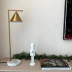 Styled for the season, the Clérachic lamp sits on a light wood table beside a small white nutcracker figure and magazines.