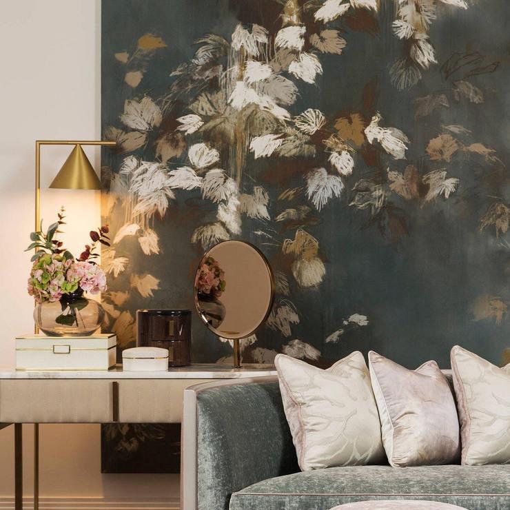 A wider room view places the Clérachic lamp on a mirrored dresser against floral wallpaper, with a teal sofa nearby.