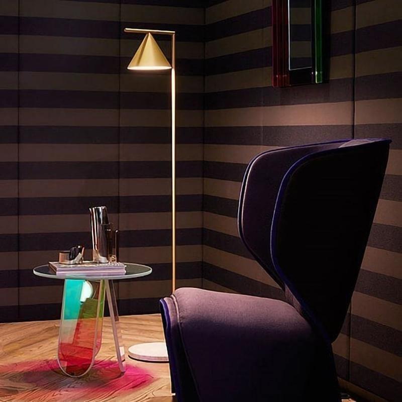 Floor lamp with spinning opal cone angled over a chair