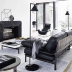Black floor lamp with opal cone lighting a corner workspace